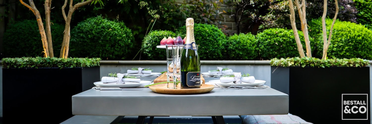 Outdoor Table Setting Surrounded By Rendered Walls - Photo by Harvey Dyson, garden by Bestall & Co.